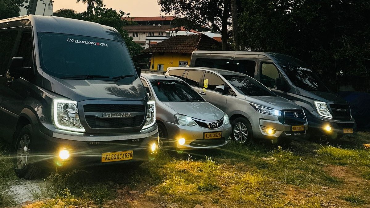 Force Urbania vans and cars of the Kerala Taxi Cab fleet parked at dusk